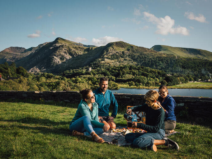 Friends having a picnic in grassland by a glacially formed lake.