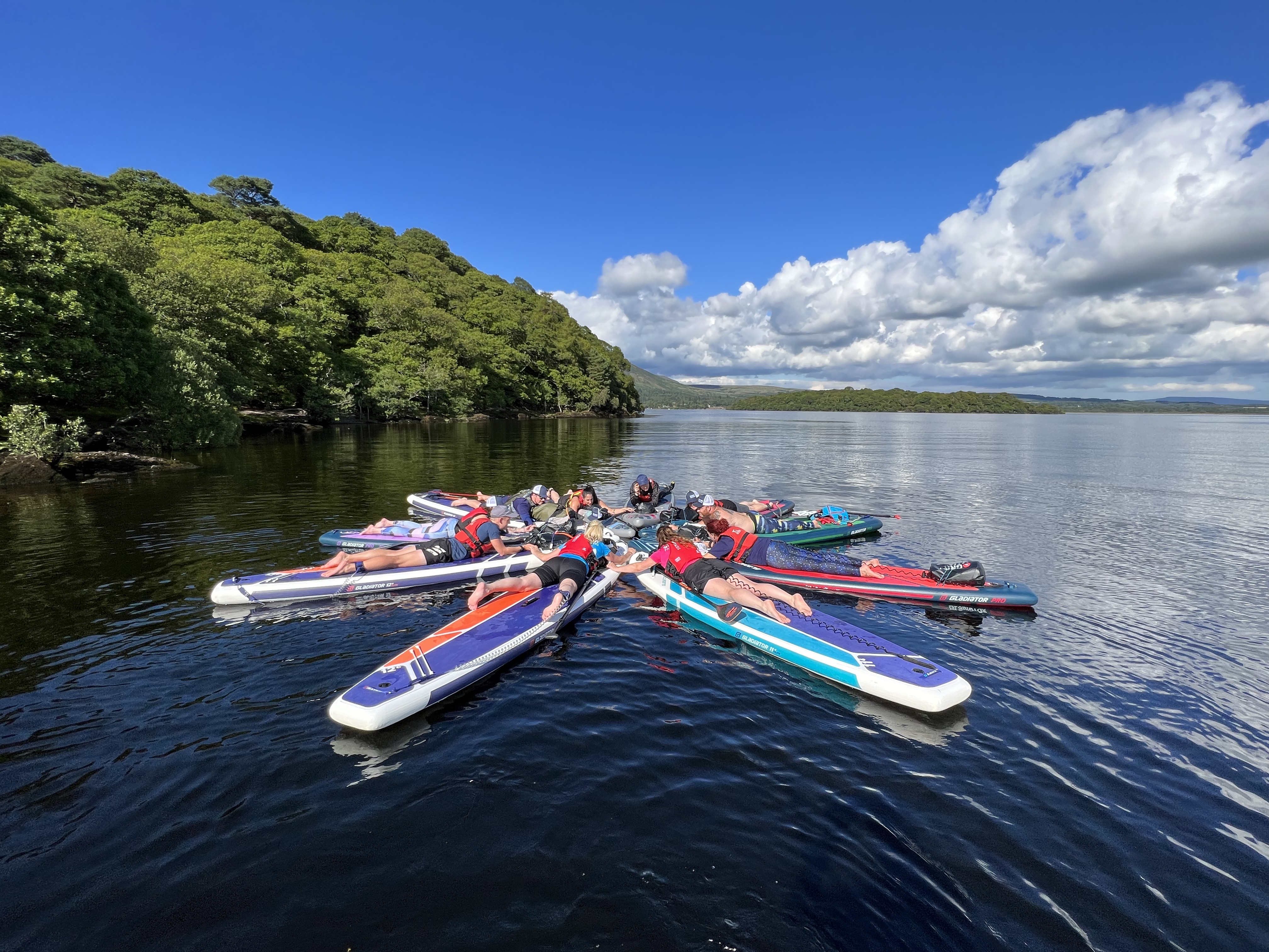 Paddleboarders laying down and forming a shape in the River Clyde in Glasgow