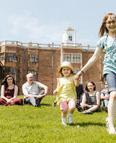 Children and parents sitting on the fields around Temple Newsam in Leeds