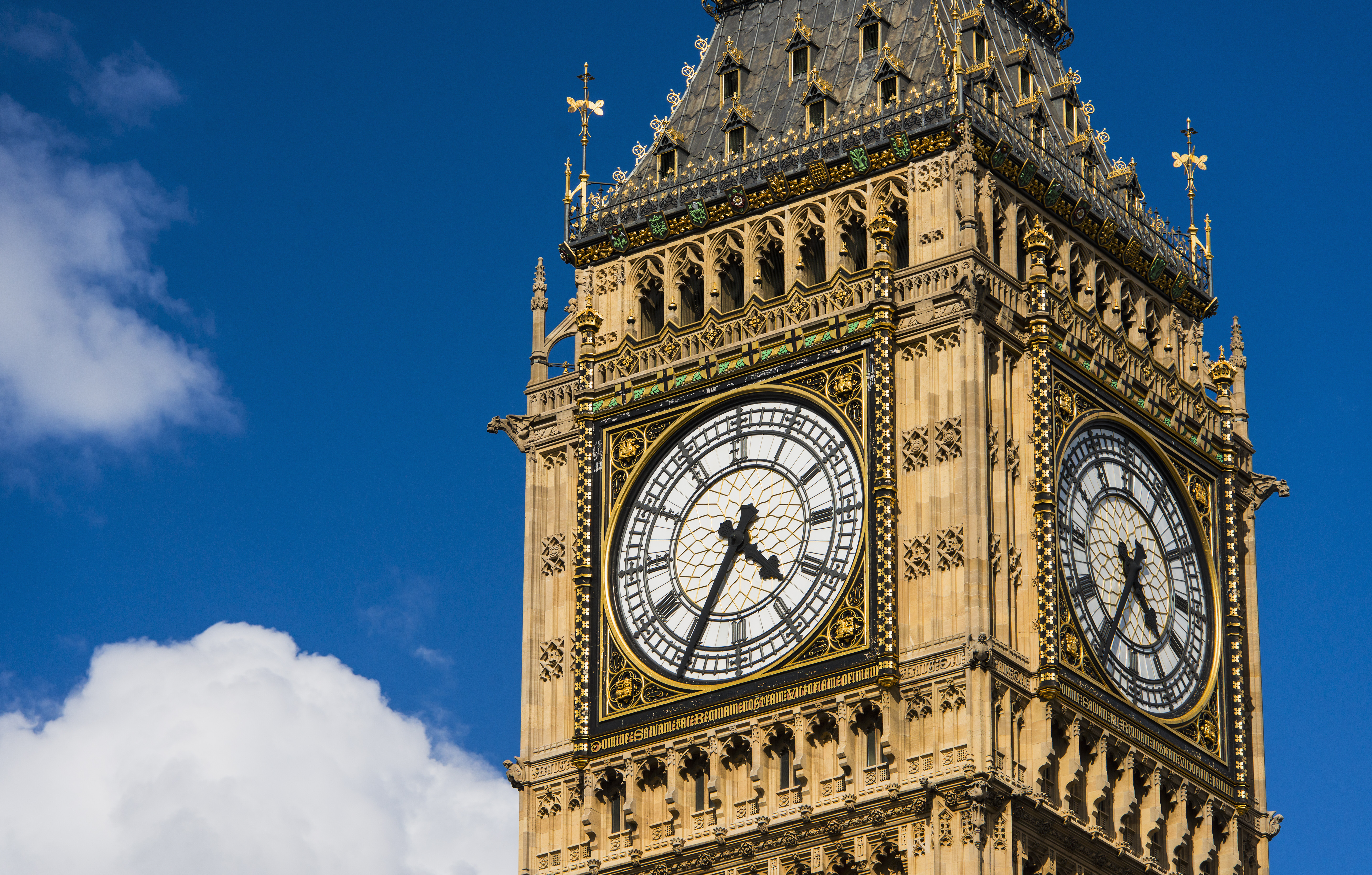 Close up view of the ornate clock face on a bright sunny day.