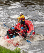 Eine Gruppe von Menschen beim Rafting in wasserdichter Sicherheitsausrüstung