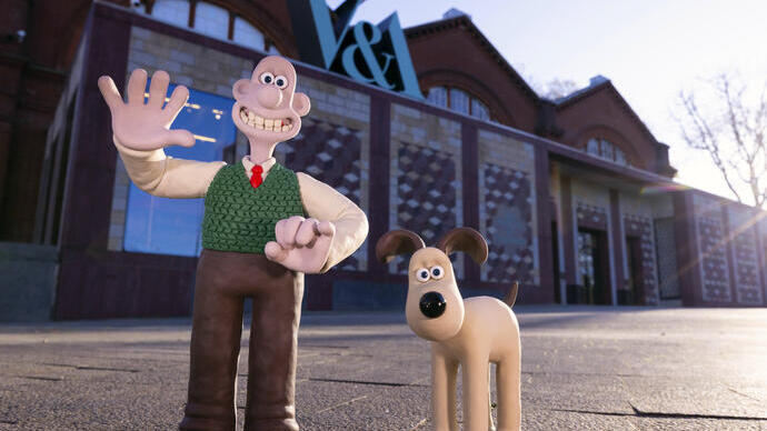 Due personaggi in plastilina, un uomo e un cane, davanti a un edificio vittoriano rosso.