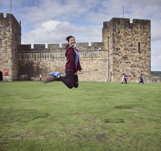 Woman on a broomstick outside a castle