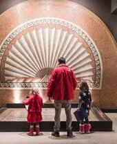Una familia examinando una exposición en el Museo Verulamium, St Albans