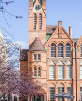 Historic building, trees in bloom on its side