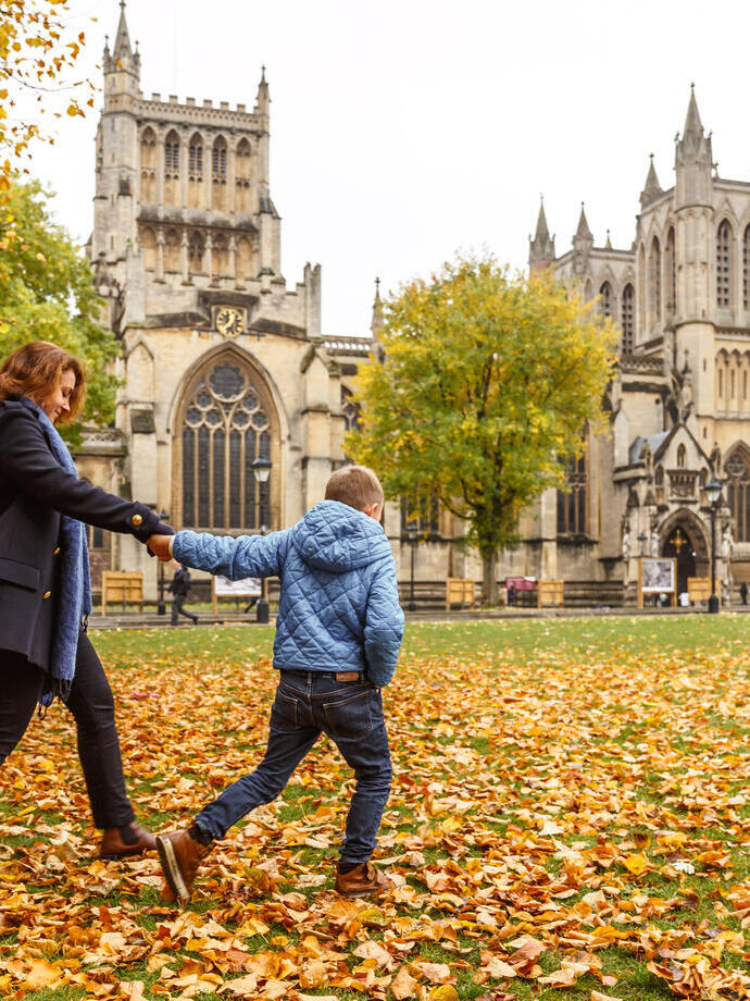A woman and child walking outside Bristol Cathedral