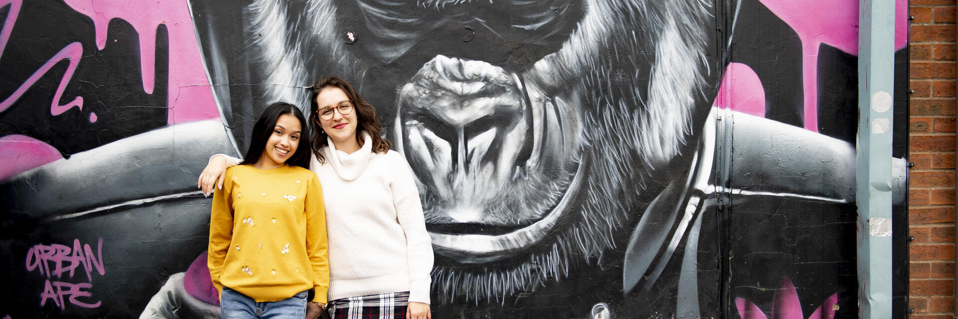 two people stand in front of Gorilla artwork by Gnasher