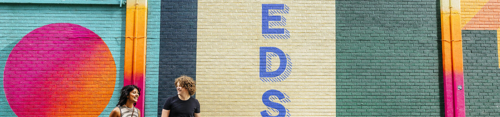 A woman and a man walk passed street art