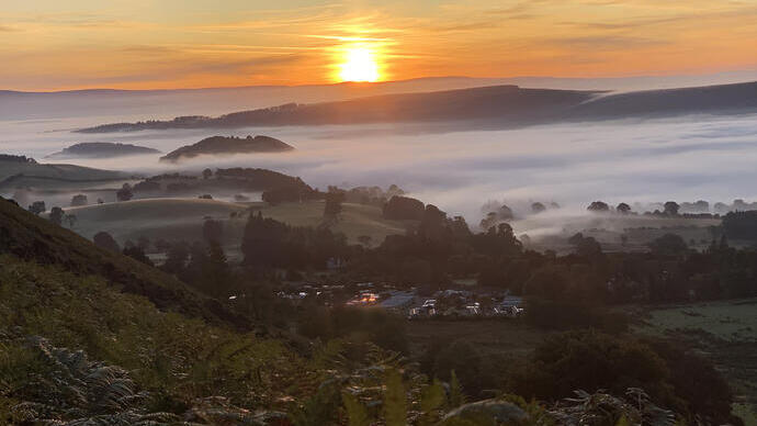 Zonsopgang en mist boven een camping op het platteland.