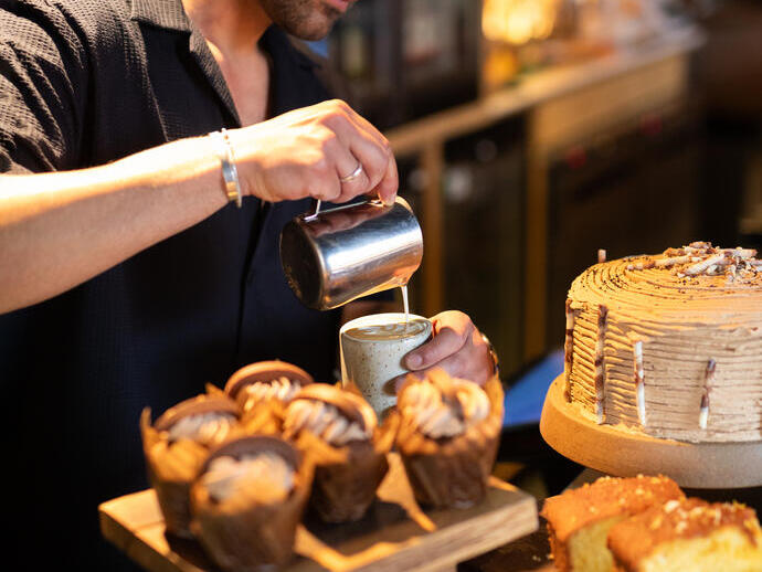 A Barista makes coffee at in a local cafe.
