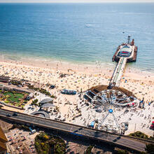 Aerial view of Bournemouth Pier looking out to sea with beach full of people