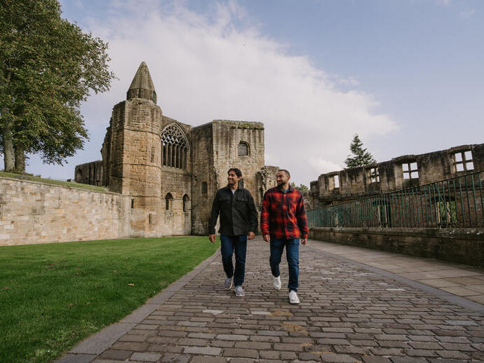 Two men walking by an Abbey Nave.