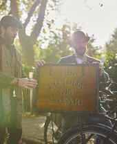 Dos guías turísticos sosteniendo un cartel en una plaza de la ciudad para una visita guiada