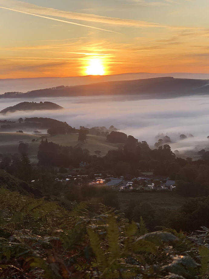 Sunrise and mist over countryside camping grounds.