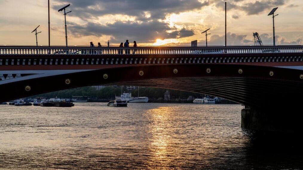 Eine Brücke über einen Fluss bei Sonnenuntergang.