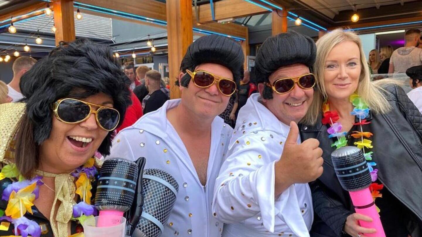 Zwei Elvis-Imitatoren posieren mit Menschen beim Elvis-Festival in Porthcawl, Wales