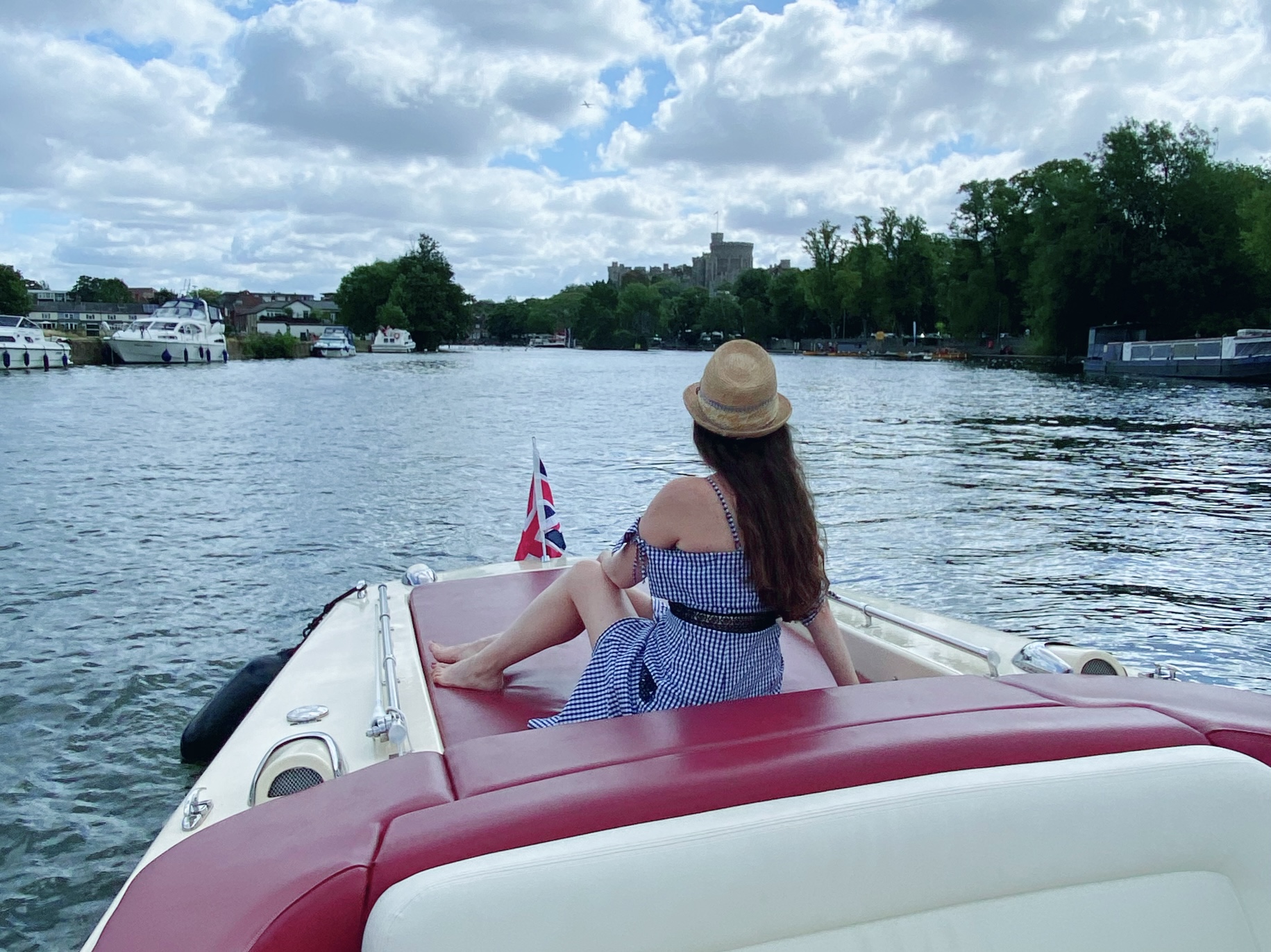 A woman sitting on a boat travelling down the River Thames in Windsor