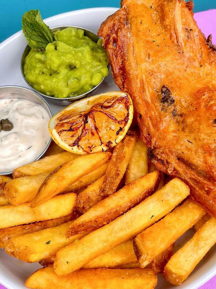 Fish and chips on a plate in Wholesome Junkies, Manchester