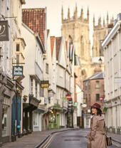 Woman walking through a narrow historic street in a city