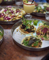 Platos de comida en una mesa de un restaurante en un patio de comidas