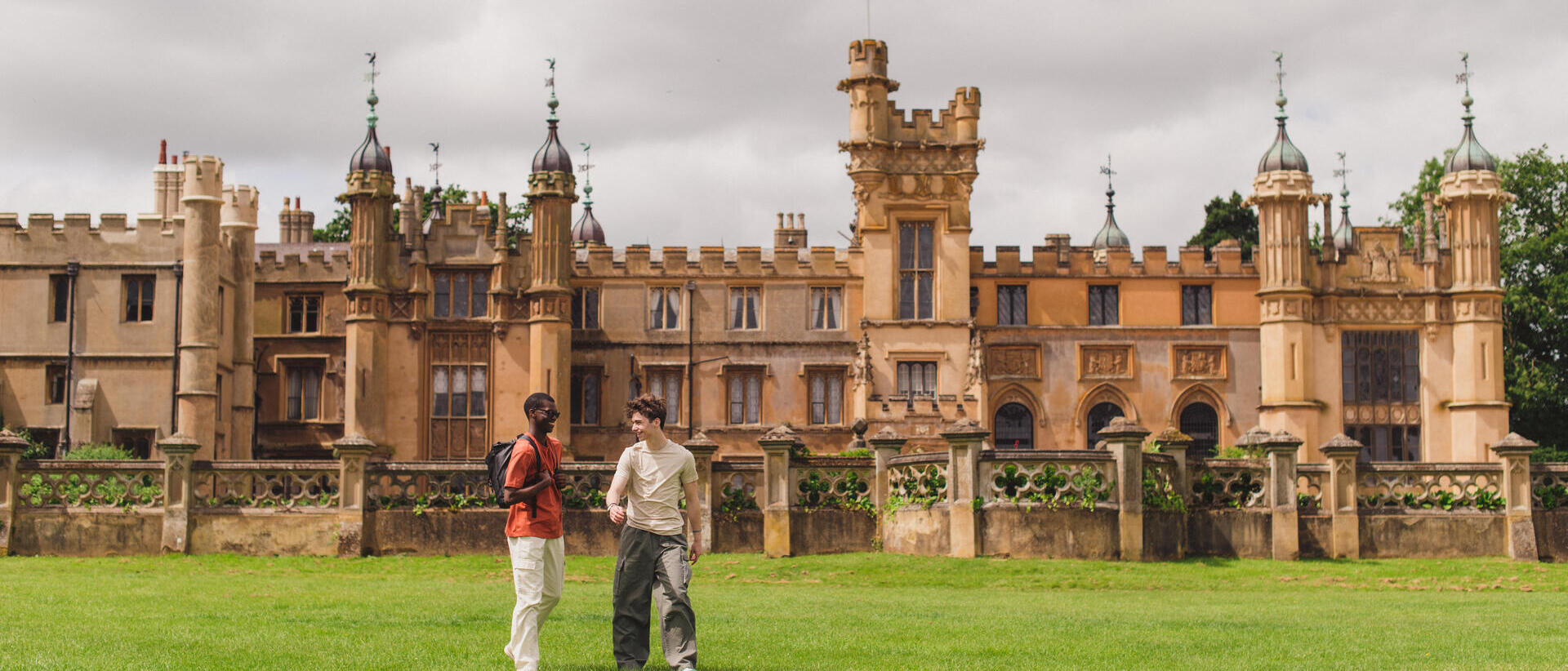 Two young men walk in the grounds of a heritage house