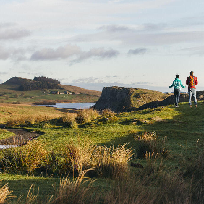 Dos jóvenes caminando por la campiña de Northumberland, Reino Unido.