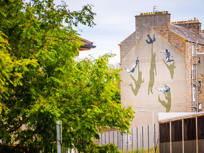 A street art mural on the side of a house.