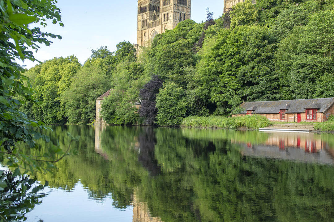 A view of a river with a Cathedral beyond.