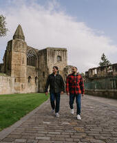 Two men walking by an Abbey Nave.