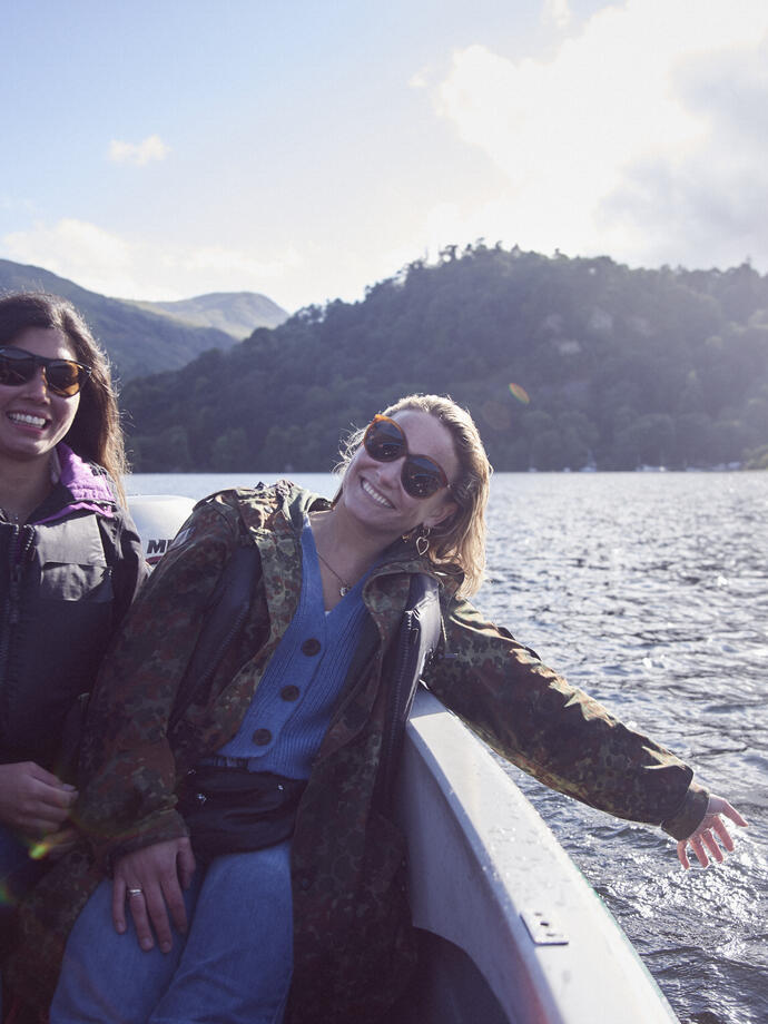Two women wearing sunglasses on a boat on the lake