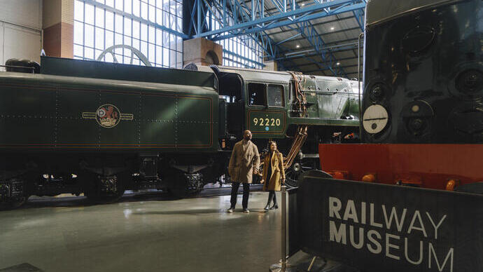 Een man en een vrouw lopen door het nationale spoorwegmuseum in York