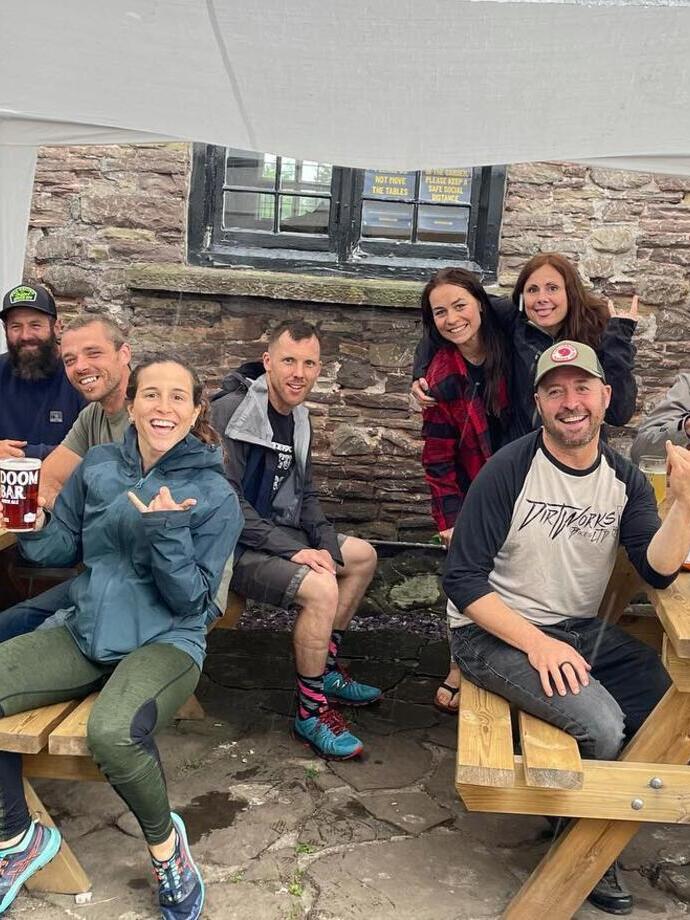 A group of hikers and people sat on tables outside The Skirrid Mountain Inn in Avergavenny, Wales