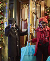 امرأة تخرج من مبنى حاملة أكياس التسوق