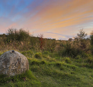 Open field with a gravestone reading: Clan Fraser