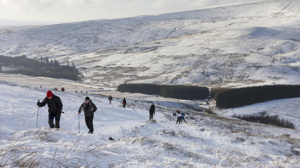 Groupe de randonneurs équipés de bâtons de randonnée dans la neige profonde