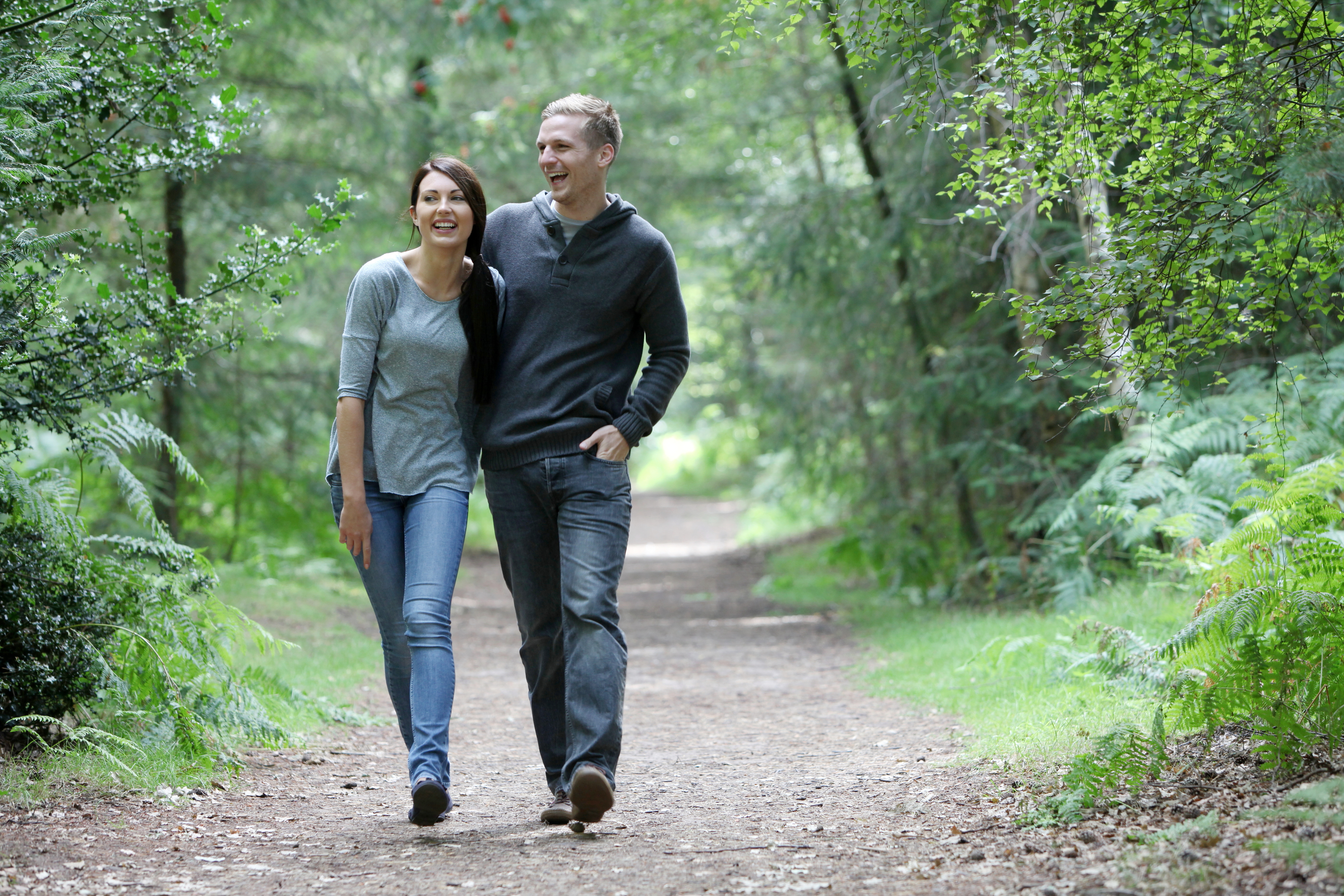 Two people walking along a path in Thetford Forest