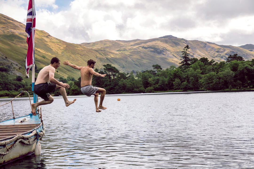 Deux hommes sautant d'un bateau dans le lac