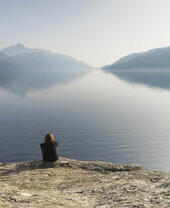 A woman sitting and looking out across Loch Lomond