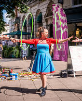 A performer with hula hoops outside as part of Norwich Summer Sessions