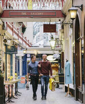 A gay couple, with arms linked, shopping indoors
