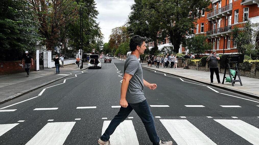 Un hombre cruzando la calle frente a los estudios Abbey Road, una recreación de la famosa portada del álbum de The Beatles