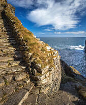 Whaligoe steps - steep stony stairs leads all the way down to the small beach below high cliffs near Whaligoe village, Highlands of Scotland.