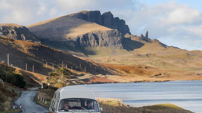 Wohnmobil auf einer malerischen Straße neben einem See