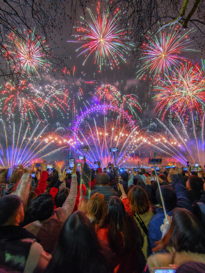 A crowd watching fireworks celebrating New Year's Eve