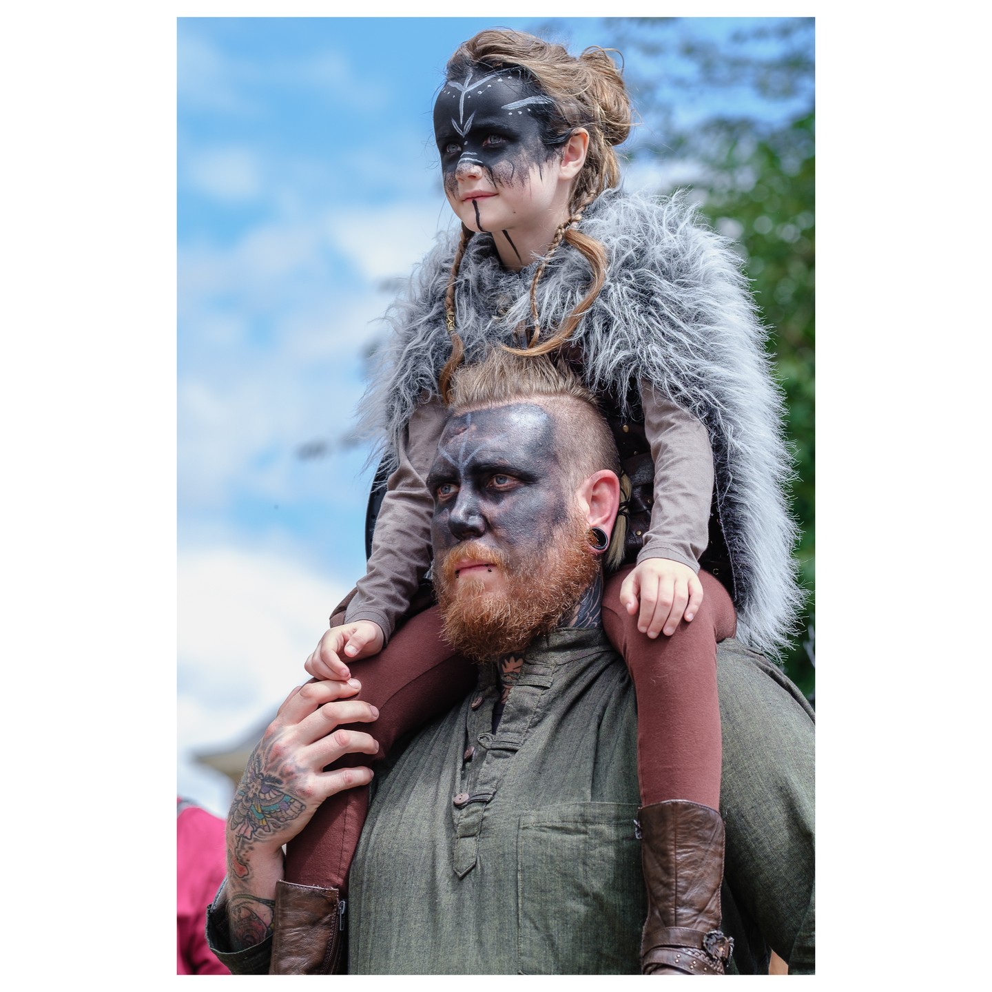 Man carrying child on his shoulders wearing Viking costume and facepaint, Jorvik Viking Centre, York