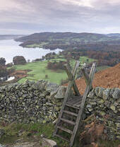 Stile over a drystone wall overlooking landscape of valleys