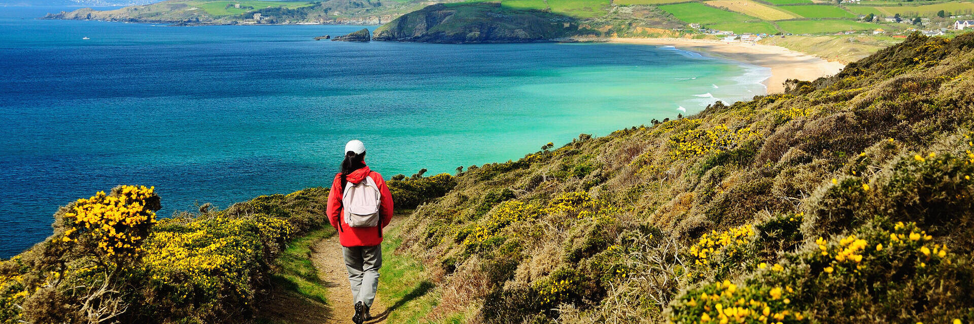 A person on a footpath on the coastal path near sea