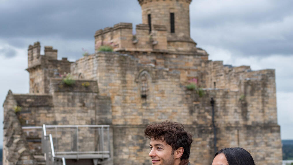 Un hombre y una mujer contemplan las vistas desde un castillo