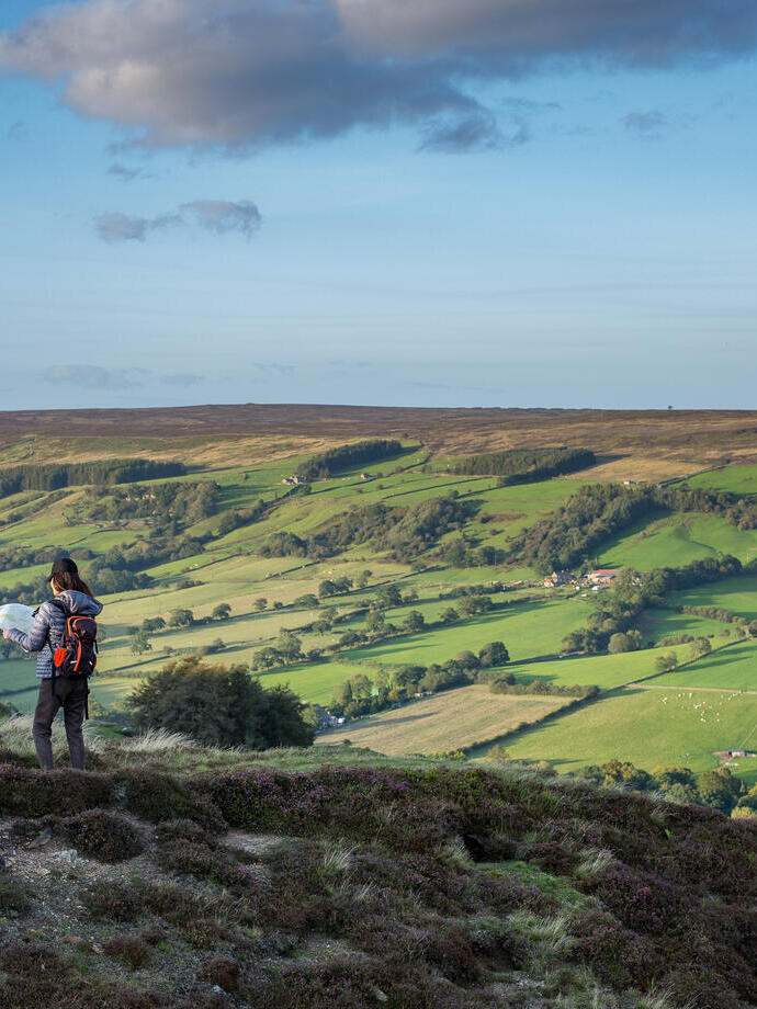 Two women checking the map on a hillside