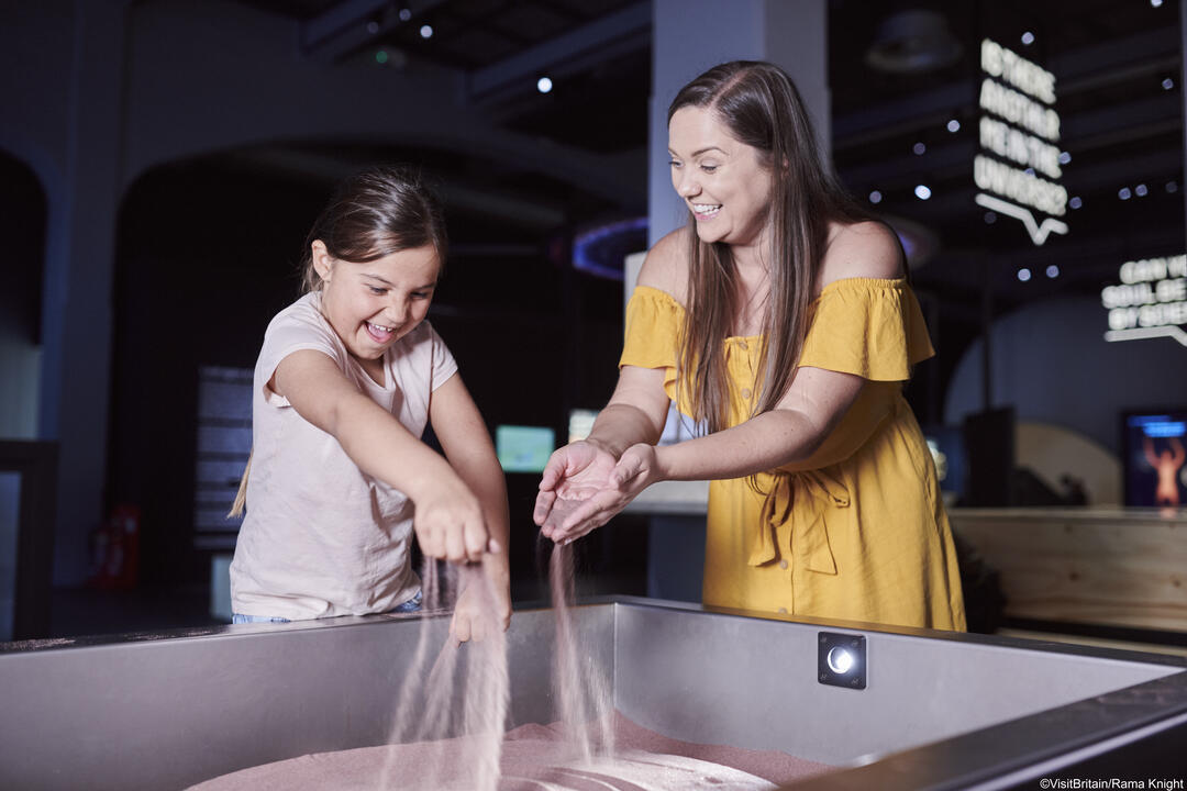 Woman and child playing an interactive display in a museum